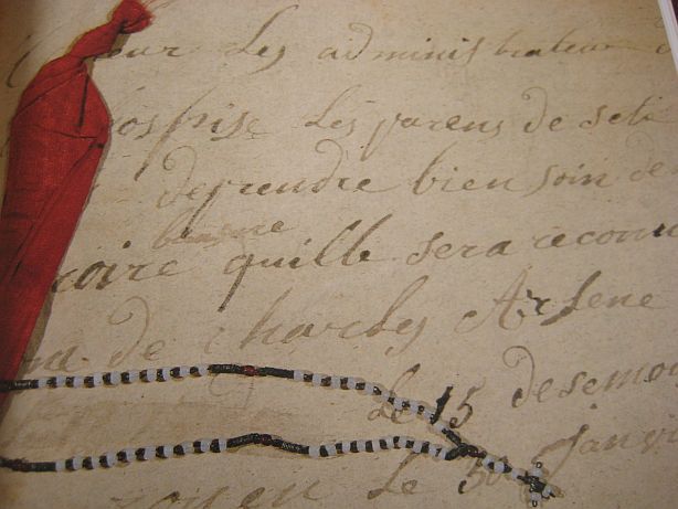 Lettre associée à un morceau d'étoffe et à une croix par une maman en France (visible au musée britanique des enfants trouvés)